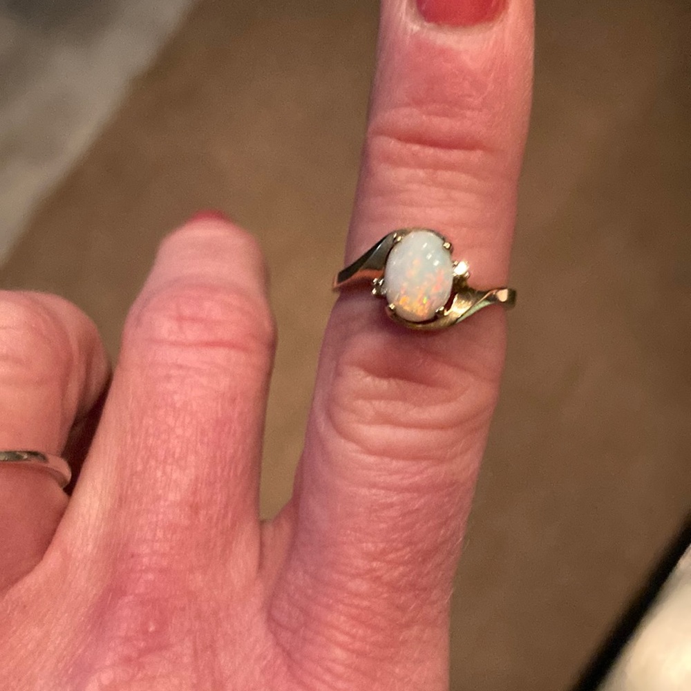 Genuine oval shaped Opal set in 10k gold with two small diamonds.